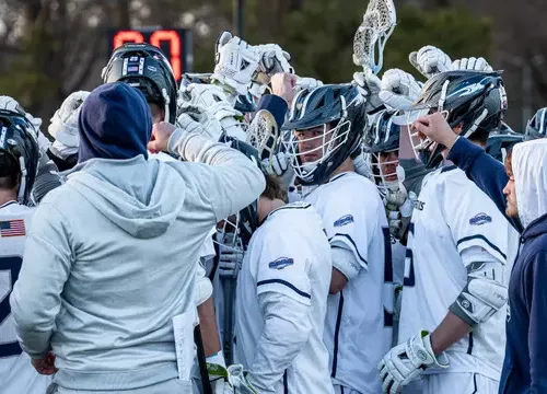 VWU Men's Lacross team with hands in a huddle
